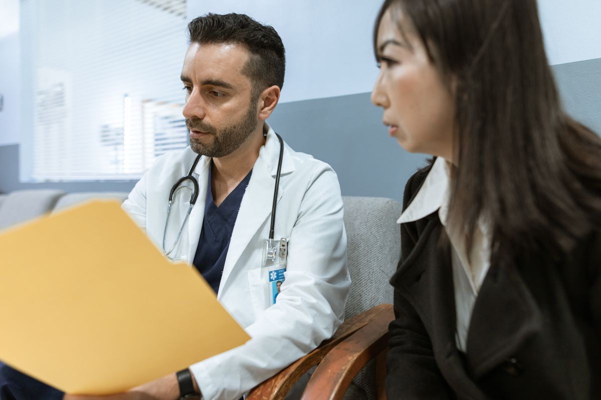 Doctor reviewing medical practice sale documents during a consultation